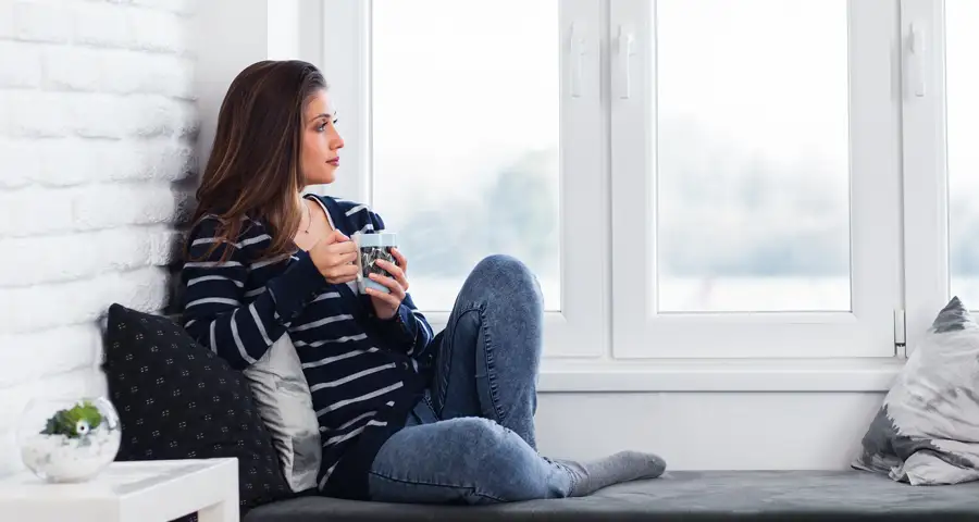 mujer en calma mirando por la ventana