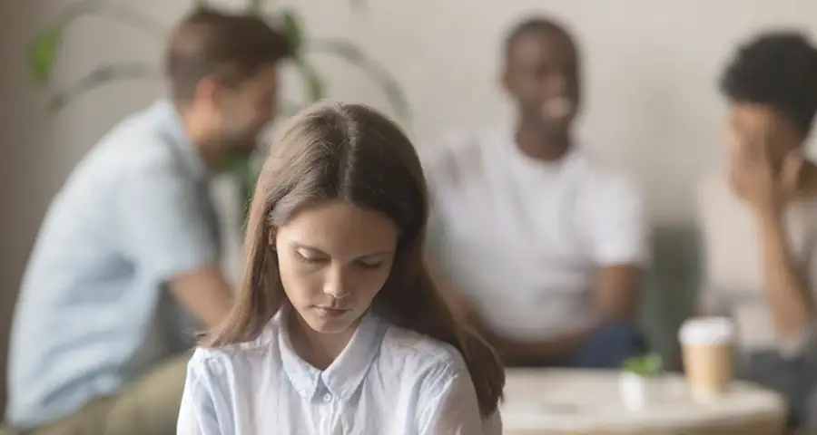 mujer sufriendo invalidación emocional con un grupo de amigos