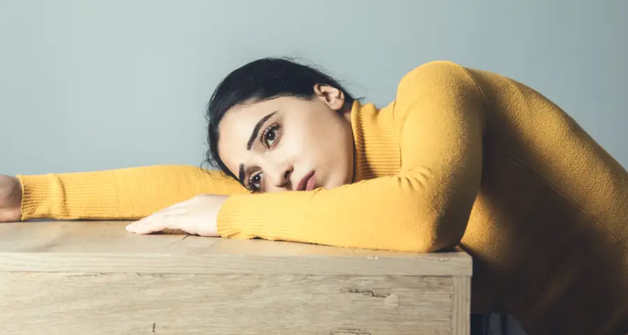 mujer triste sobre una mesa